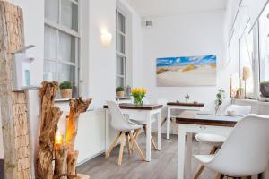 a dining room with white chairs and a table at Haus Menno Janssen - Doppelzimmer in Norderney