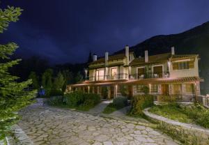a large house in the mountains at night at Guesthouse Mylona in Arachova