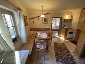 a living room with a table and a kitchen at Geigerhaus 500 Jahre - Appt A in Stuhlfelden