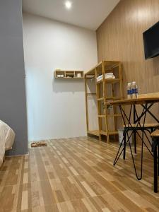 een kamer met een bureau, een tafel en een plank bij Pleiku Homestay in Pleiku