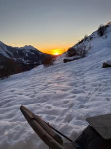 a snow covered slope with the sun setting in the background at Appartement avec Terrasse - Soleil des Alpes - Orcières-Merlette 1850 in Orcières