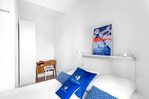 um quarto com uma cama branca e almofadas azuis em Agreeable studio with AC in le Mourillon - Dodo et Tartine em Toulon