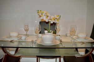 uma mesa com pratos, copos e flores em Classy Campbell Park Apartment, Balcony & Free Parking em Milton Keynes
