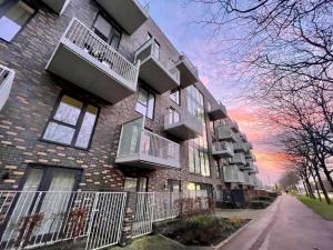um grande edifício de tijolos com varandas numa rua em Classy Campbell Park Apartment, Balcony & Free Parking em Milton Keynes