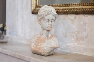 Une statue d'un buste d'une femme assise sur un comptoir dans l'établissement La Madone, à Apt