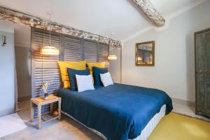 um quarto com uma cama azul e almofadas amarelas em La Madone em Apt