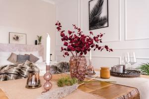 a table with a vase with red flowers on it at 90sqm 2BR Biz LOFT - 5min Central Station in Berlin
