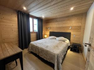 a bedroom with a bed in a wooden room at PASTORALE 2 - Bel appartement avec terrasse - Wifi - Garage in La Clusaz