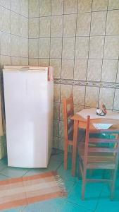 a table and a refrigerator and a table and a chair at Chales Encanto Suíço in Monte Verde