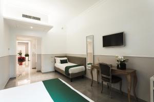 a hotel room with a bed and a desk and a television at Vaticano Luxury Guest House in Rome