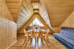 a dining room with a table and chairs and a window at By the River in Chochołów