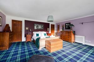 a bedroom with a bed and a dresser in it at Strathendrick House Magnificent property with Garden in Drymen