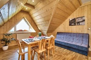 a dining room with a table and a blue couch at By the River in Chochołów +65 photos