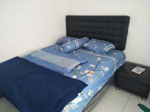 ein Bett mit blauer Bettwäsche und blauen Kissen darauf in der Unterkunft Giri Home & Travel in Ciwidey