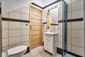 a bathroom with a toilet and a sink at By the River in Chochołów
