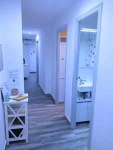 ein weißes Badezimmer mit einem Waschbecken und einem Spiegel in der Unterkunft El Terrat de la Tecla - Dúplex Casc Antic in Tarragona