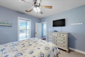 a bedroom with a bed and a flat screen tv at Packsaddle Beach House in Rockport