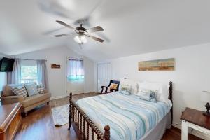 een slaapkamer met een bed en een plafondventilator bij Packsaddle Beach House in Rockport