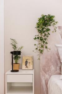 a bedside table with plants on it next to a bed at 90sqm 2BR Biz LOFT - 5min Central Station in Berlin