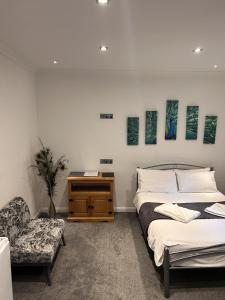 a bedroom with a bed and a desk and a chair at Rock House Bed and Breakfast in Maidstone