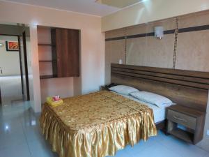 1 dormitorio con cama con colcha de oro en HOTEL ESTRELLA, en Lima