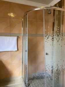 a shower with a glass door in a bathroom at Nsuku Bed and Breakfast in Thulamahashi +22 photos