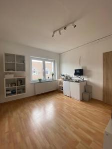 an empty living room with a kitchen and a hard wood floor at Gerolstein, Urlaub in der Eifel 2 - Ferienwohnung in Gerolstein