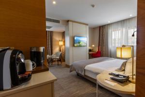 a hotel room with a bed and a desk with a tv at Kuhla Hotel in Trabzon