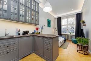 a kitchen with gray cabinets and a sink at Studio 5 Min to Riga Old Town & Christmas Market in Rīga