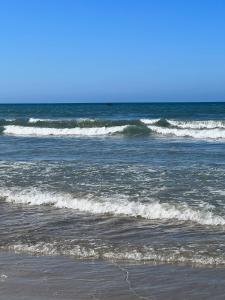 a group of waves in the ocean on a beach at Apartamento - Pé na Areia in Itapema