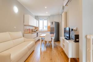 un soggiorno con divano bianco e una cucina di WHITE HOME - METRO MASSAUA a Torino
