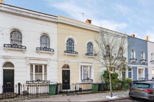 a white house with a car parked in front of it at Charming Character House London in London