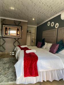a bedroom with two beds with red and white sheets at Nsuku Bed and Breakfast in Thulamahashi