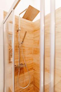bagno con doccia e parete in legno di WHITE HOME - METRO MASSAUA a Torino