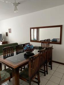a dining room with a glass table and chairs at Apartamento - Pé na Areia in Itapema