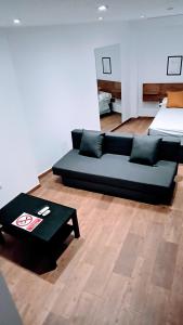 a living room with a couch and a bed at apartamento Ciempozuelos II in Ciempozuelos