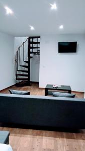a living room with a couch and a staircase at apartamento Ciempozuelos II in Ciempozuelos