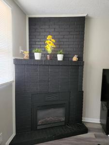 a black brick fireplace with potted plants on it at Comfortable 2bed1bath Unit Sleeps 4 Close To Town Center Downtown Beach Mayo Clinic in Jacksonville