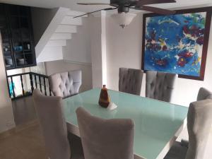 comedor con mesa de cristal y sillas en Apartamento Rodadero, Edificio Palanoa 308, en Santa Marta