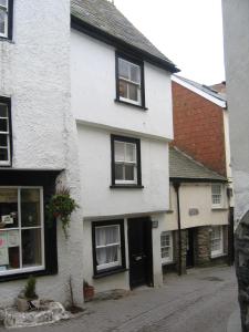 a white house with black windows on a street at Jacobs Cottage in Port Isaac