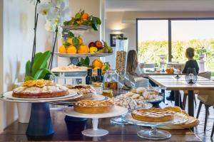 une table avec plusieurs assiettes de tartes et autres pâtisseries dans l'établissement Nèroli Bio Relais, à Catane