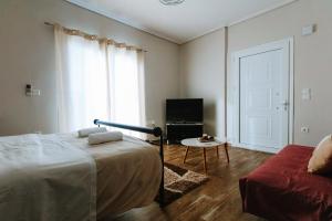 - une chambre avec un lit, une table et une fenêtre dans l'établissement 3 Bros Studio, à Chalcis
