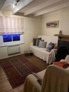 a living room with a white couch and a fireplace at Jacobs Cottage in Port Isaac
