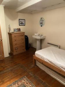 a bedroom with a bed and a sink in it at Jacobs Cottage in Port Isaac