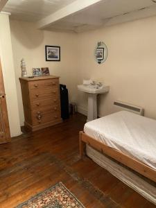 a bedroom with a bed and a sink in it at Jacobs Cottage in Port Isaac +26 photos
