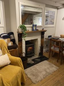 a living room with a fireplace and a mirror at Jacobs Cottage in Port Isaac