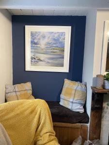 a bedroom with a blue wall with a bed and a painting at Jacobs Cottage in Port Isaac +39 photos