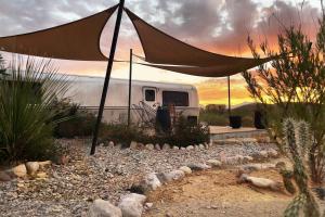 a camper with a tent in front of it at Desert Pearl ⁠— Quick Drive from Big Bend in Terlingua