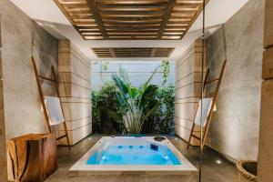 a hot tub in a room with a plant at CASA LUCIANA Condesa in Mexico City