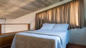 a bedroom with a large bed with a window at Pousada Rosa Tropicalia in Praia do Rosa +61 photos